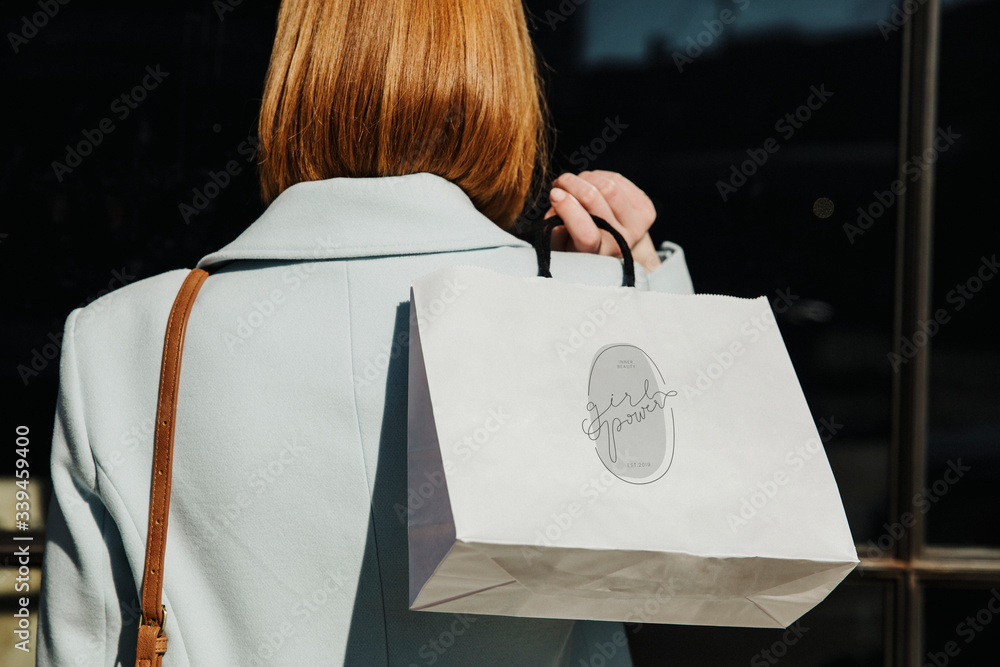 Woman carrying a minimal paper bag