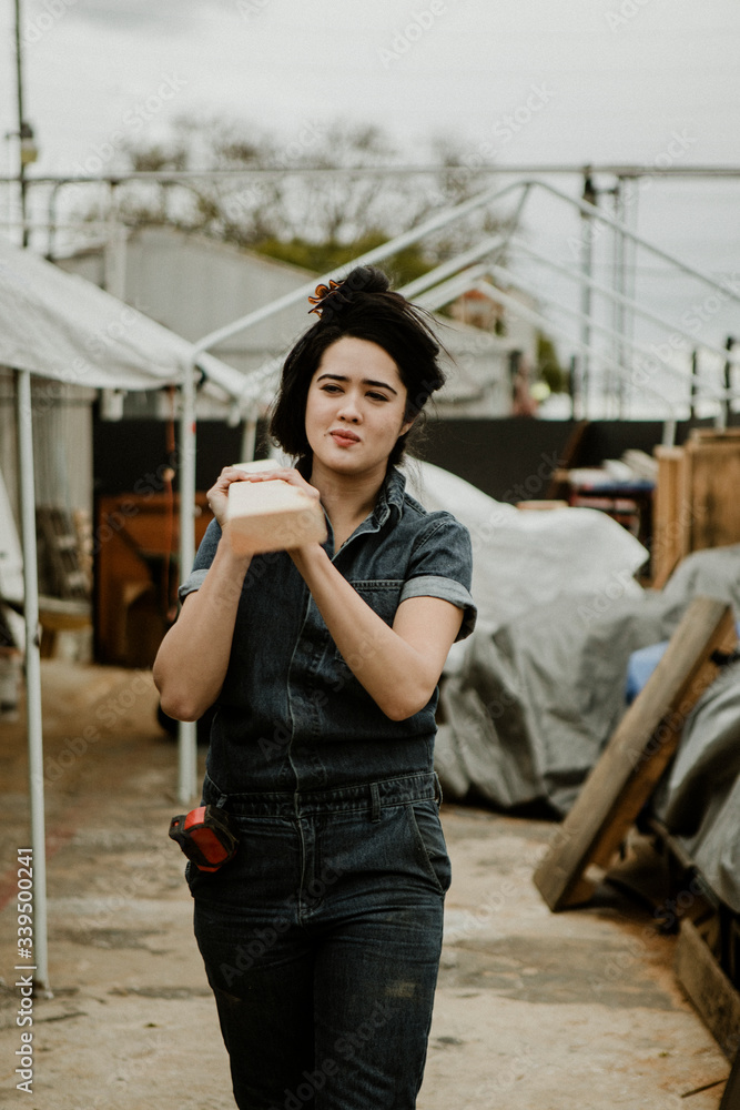 Carpenter carrying a plank