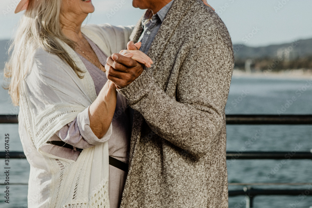 Happy senior couple dancing by the sea