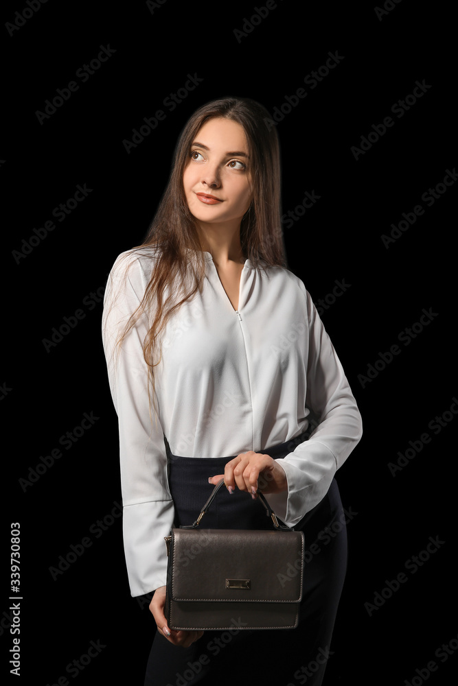 Beautiful young businesswoman on dark background