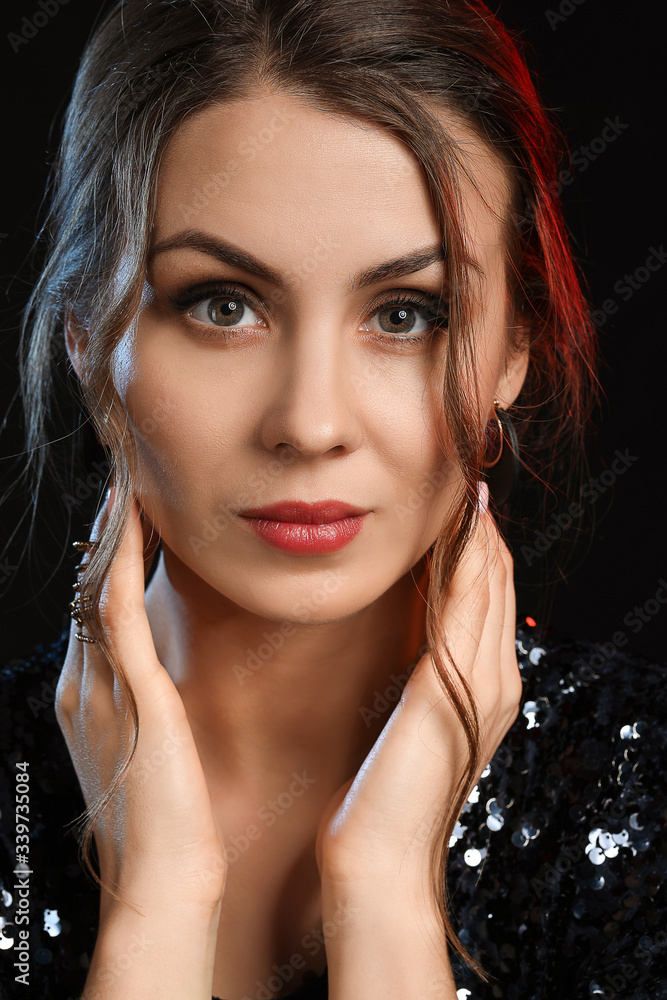 Young woman with beautiful jewellery on dark background