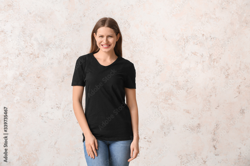 Young woman in stylish t-shirt on light background