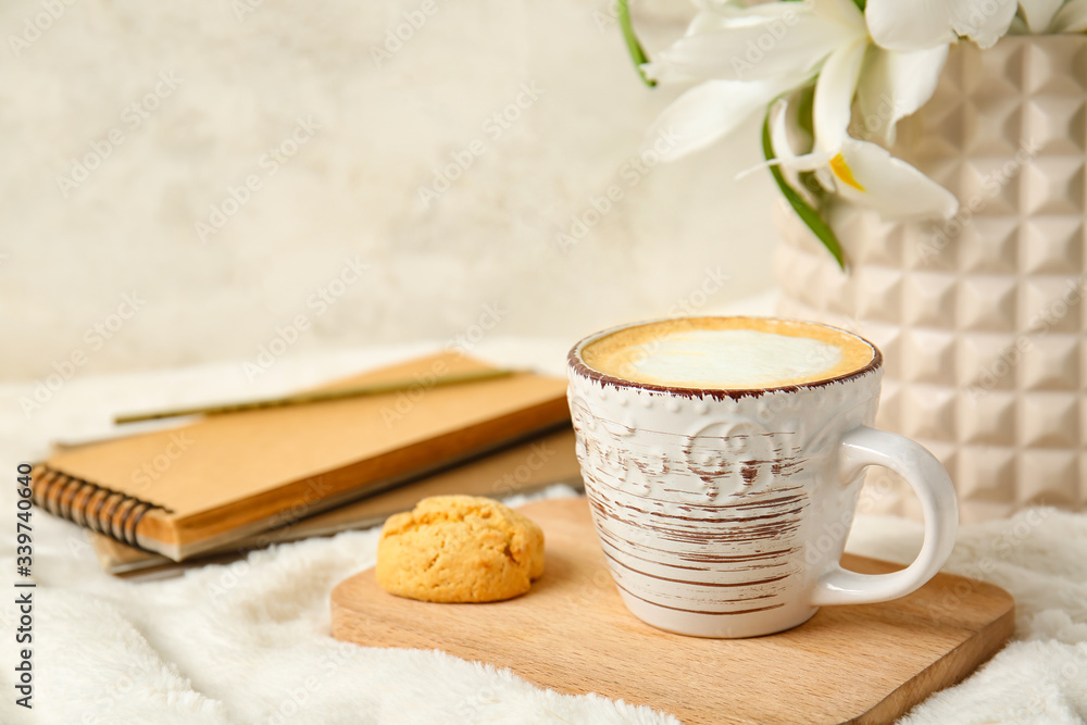 一杯咖啡、鲜花、饼干和软格子笔记本