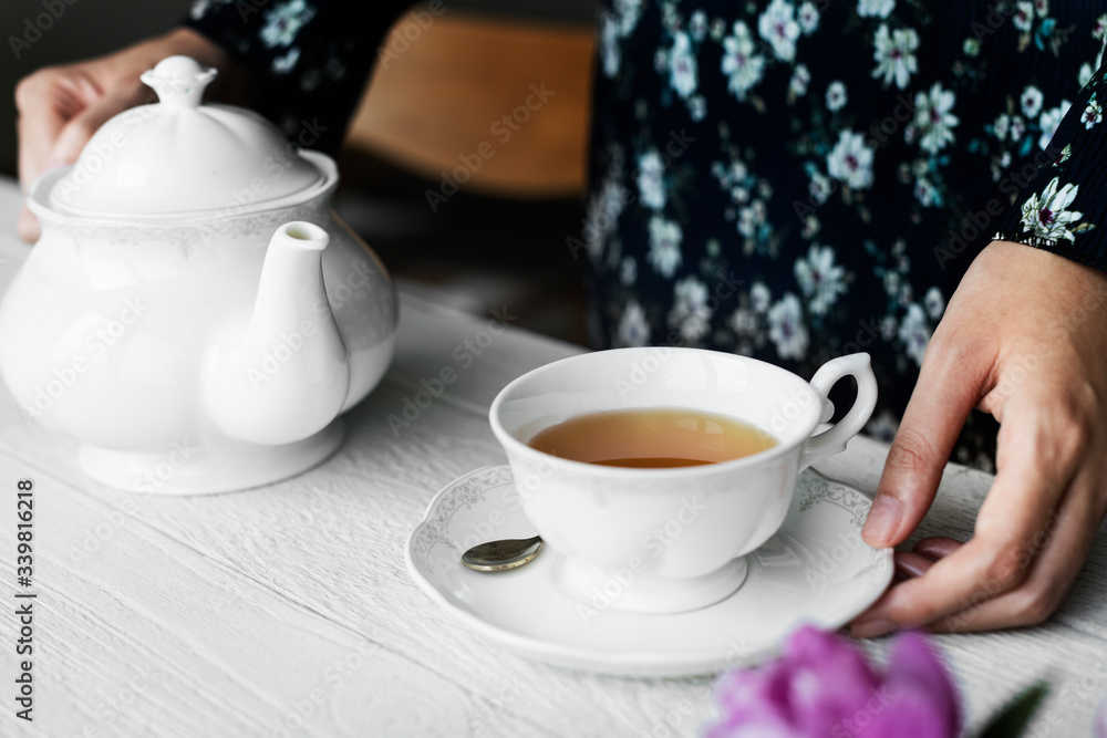 Woman helping herself with a cup of nice hot tea