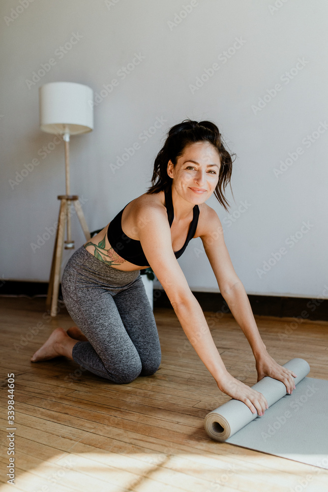 Woman rolling yoga mat