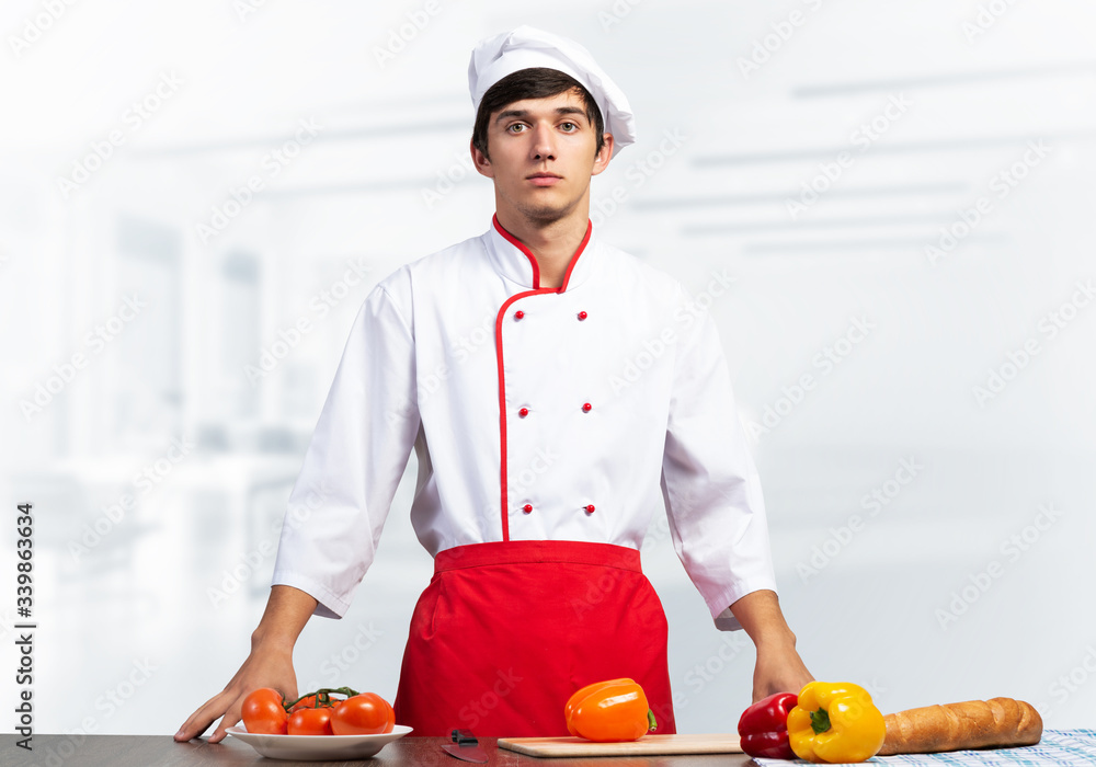 Young male chef standing near cooking table