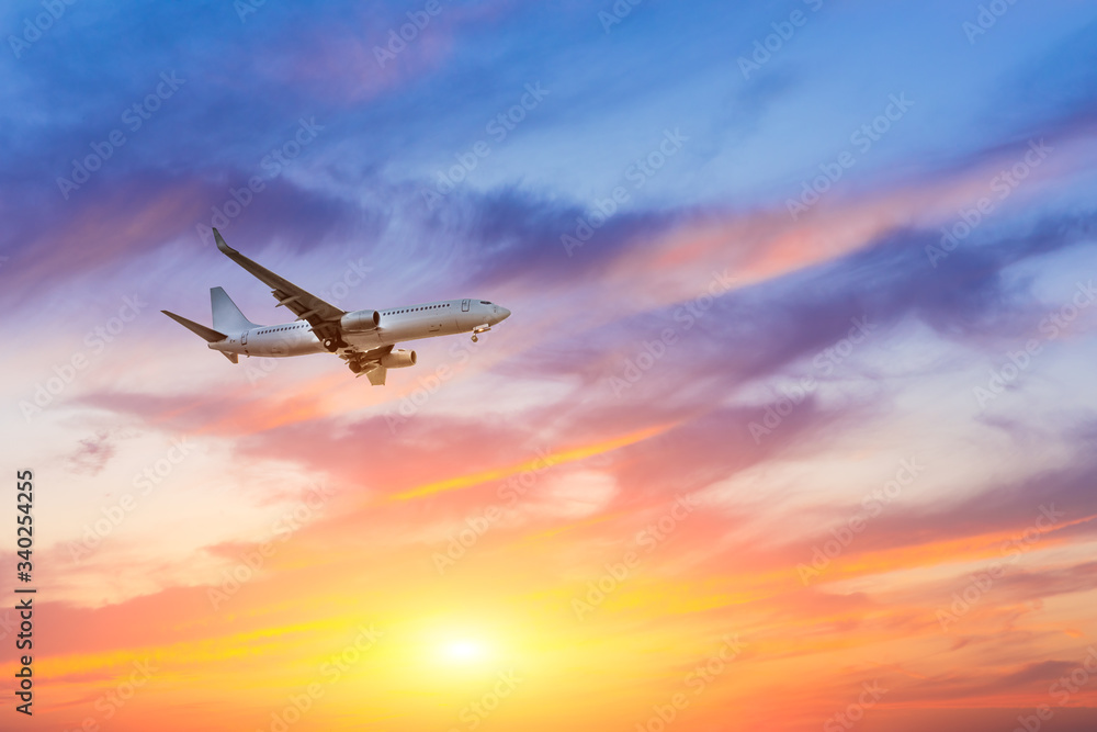 Commercial airplane flying in beautiful sky at sunset,travel concept.