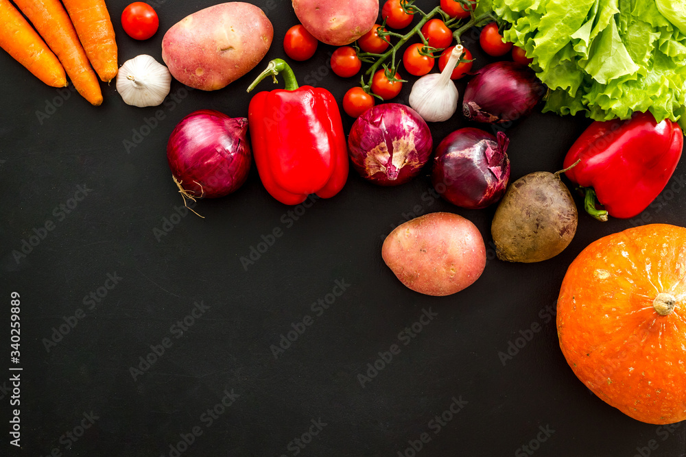 Set of autumn vegetables - potato, cucumber, carrot, greenery - on black background top-down copy sp