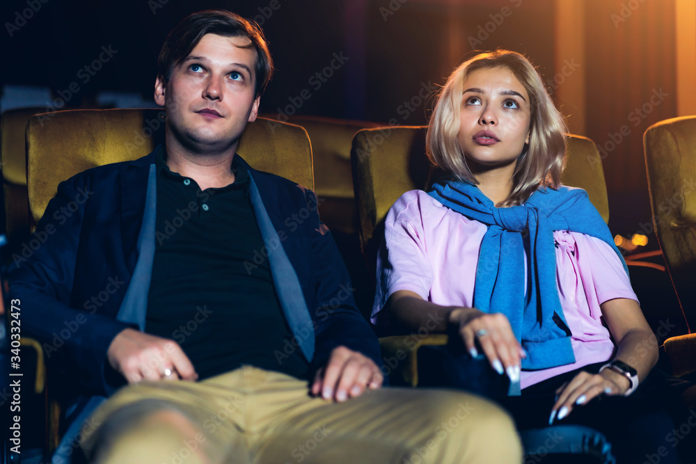 Caucasian lover enjoying to watch movie and eating popcorn together in the cinema