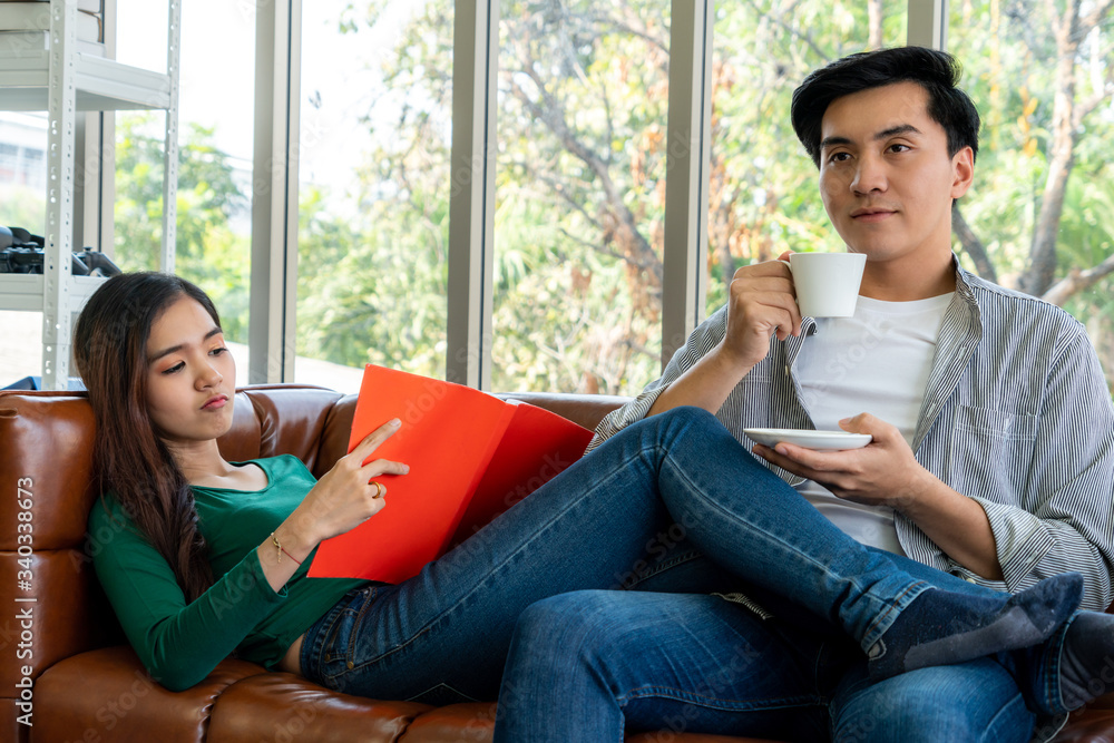 Happy Asian couple drink coffee at home. Love relationship and lifestyle concept.