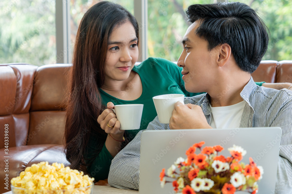 Happy Asian couple drink coffee at home. Love relationship and lifestyle concept.