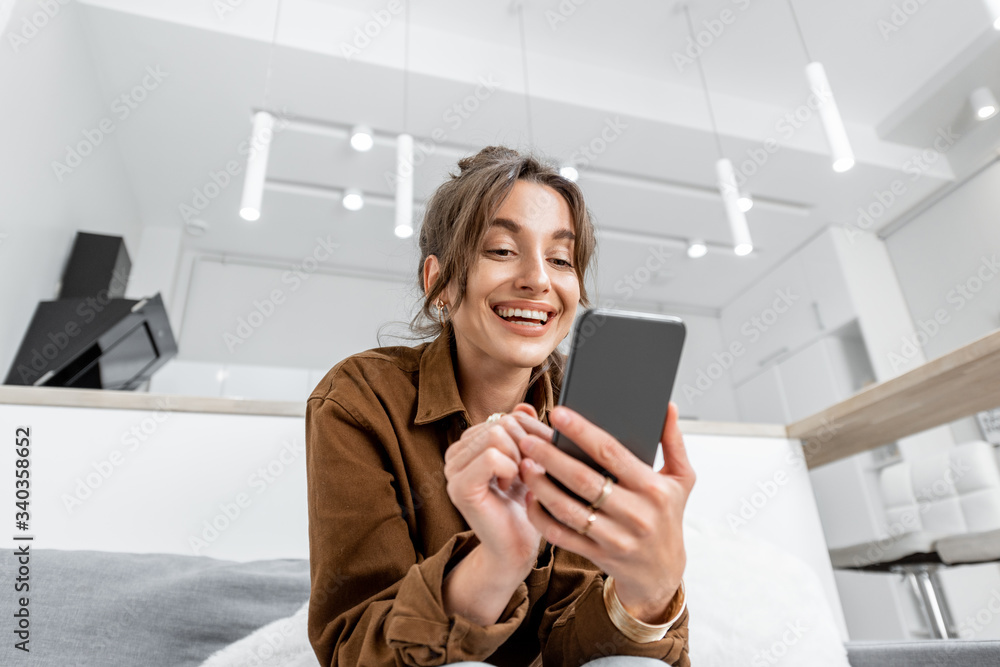 Cheerful woman with a phone at home