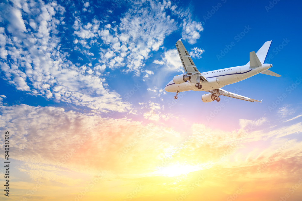 Commercial airplane flying in beautiful sky at sunset,travel concept.