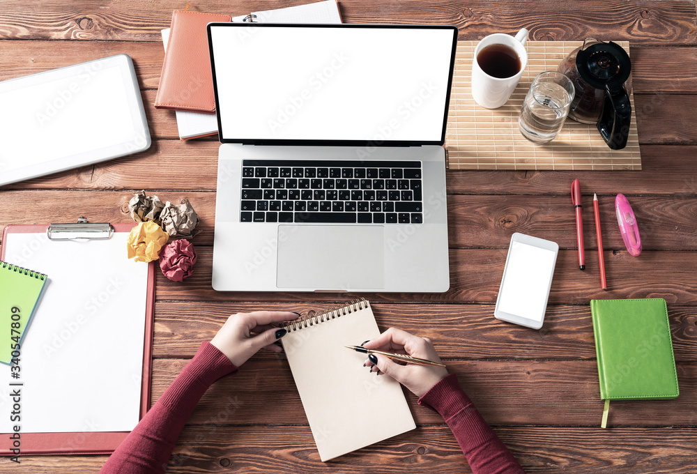 Woman writing in notebook with pen at desk