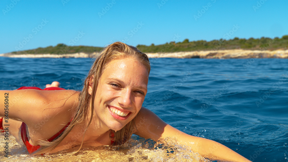 肖像：年轻女子在一个完美的夏日冲浪，享受假期。