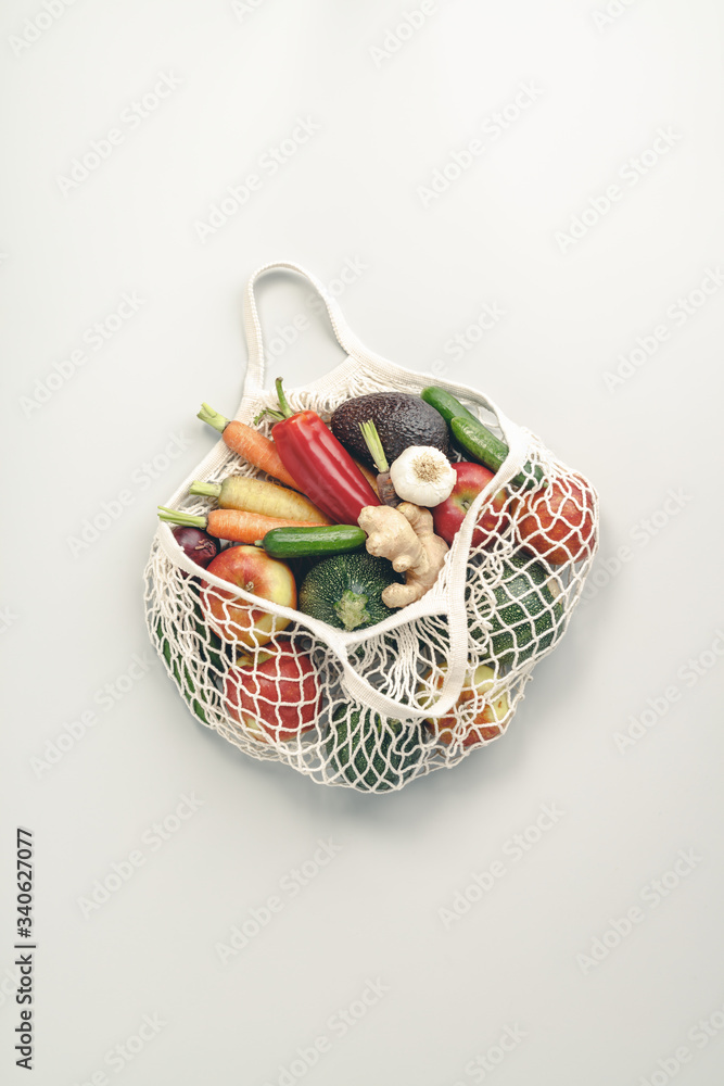 Fresh organic fruits and vegetables in mesh textile bag