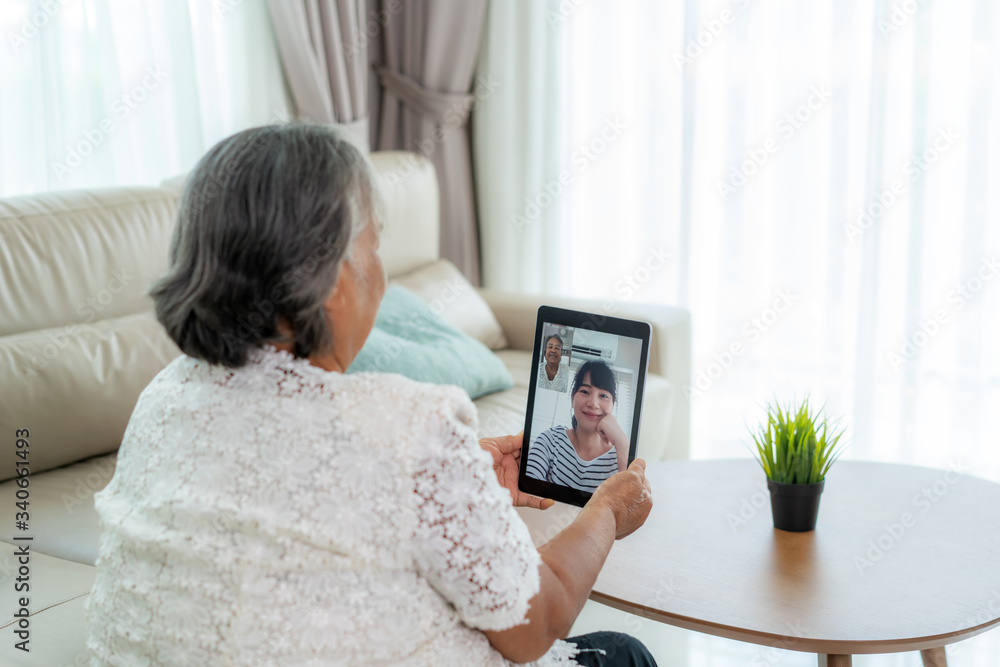 Asian elderly woman virtual happy hour meeting and talking online together with her daughter in vide