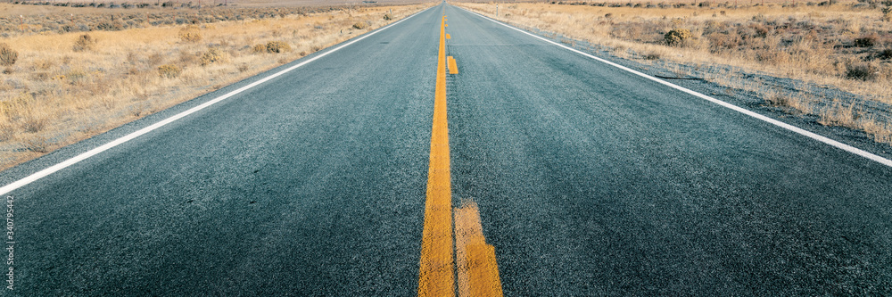 穿过沙漠的笔直长路，通往地平线的空旷街道，两车道沥青路线