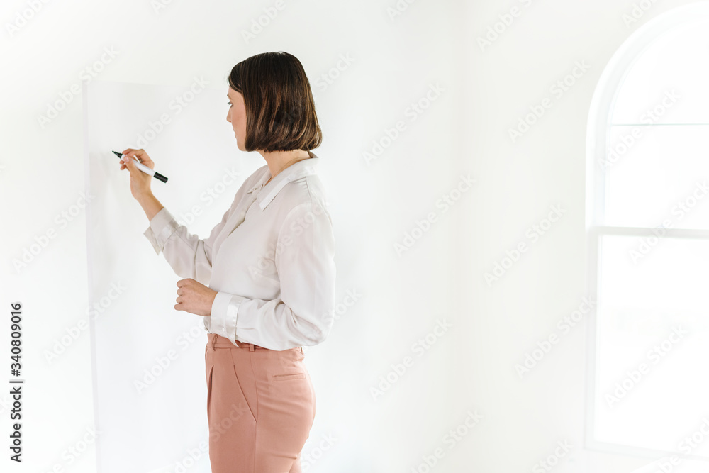 Businesswoman writing on a whiteboard 