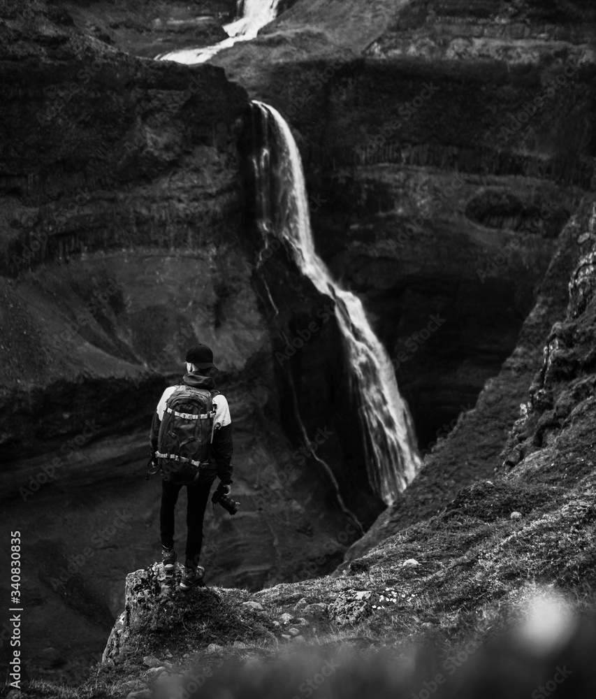 Traveler by a waterfall