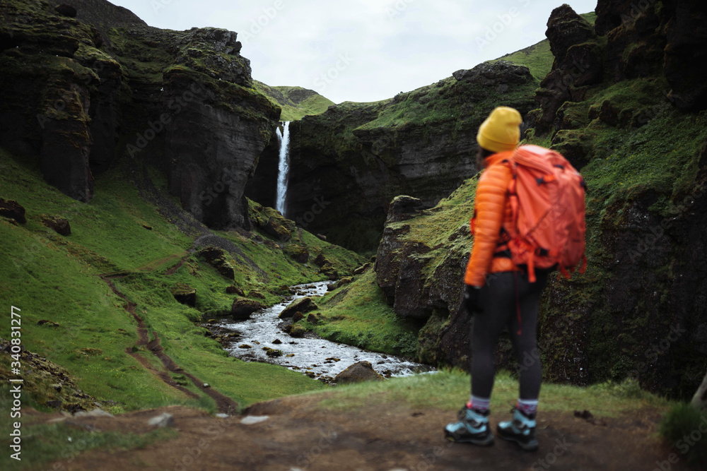 Traveler by a waterfall