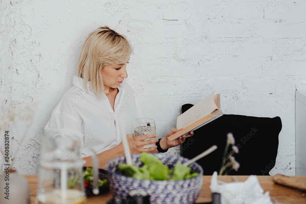 Woman reading a book at dinner