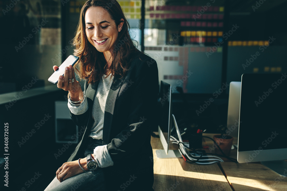 Female executive talking on speaker phone