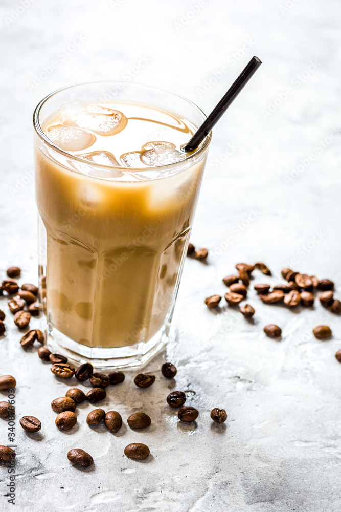 cold coffee glass with ice cubes on stone table background