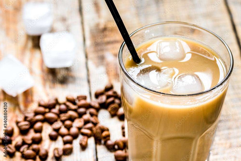 Ice coffee with milk and beans for lunch on wooden background