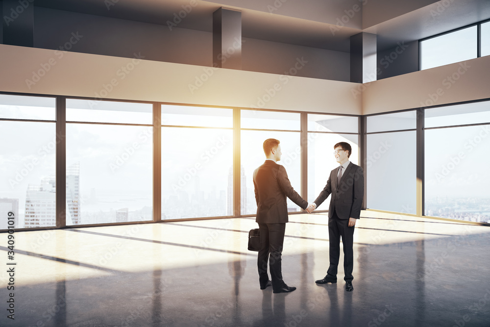 Businessmen shaking hands in office interior.