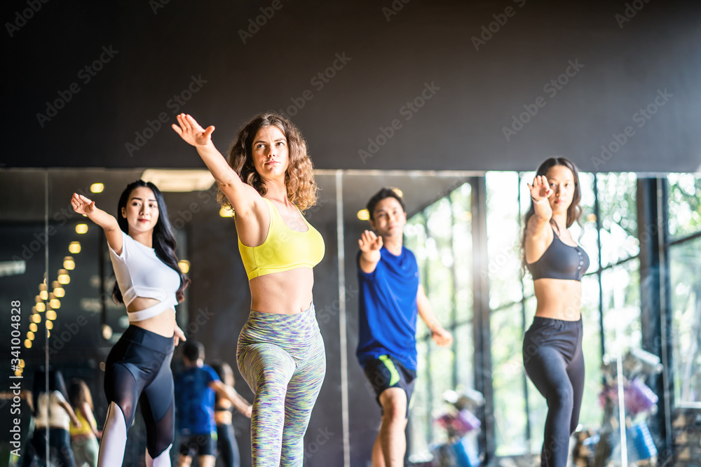 Group of multi-ethnic sport man and women practice the warrior pose in yoga class in studio gym, fit