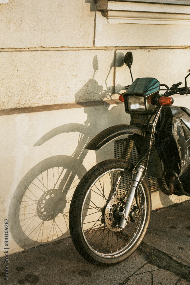 Motorbike parked by a white wall