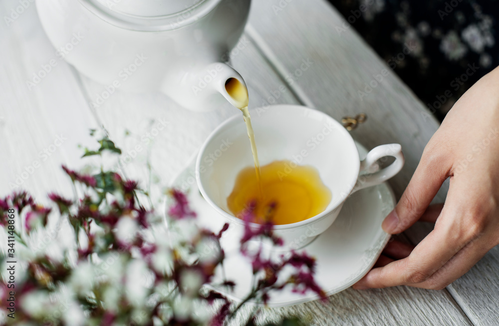 Aerial view of a woman pouring a hot tea drink