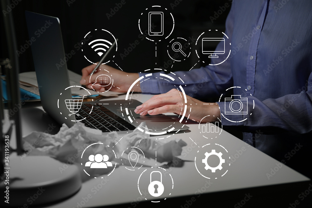 Woman working on laptop at table in evening. Concept of digital marketing