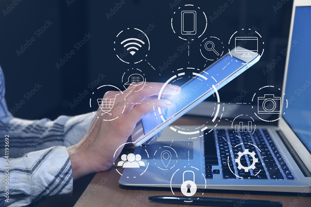 Woman working on tablet computer at table in evening. Concept of digital marketing