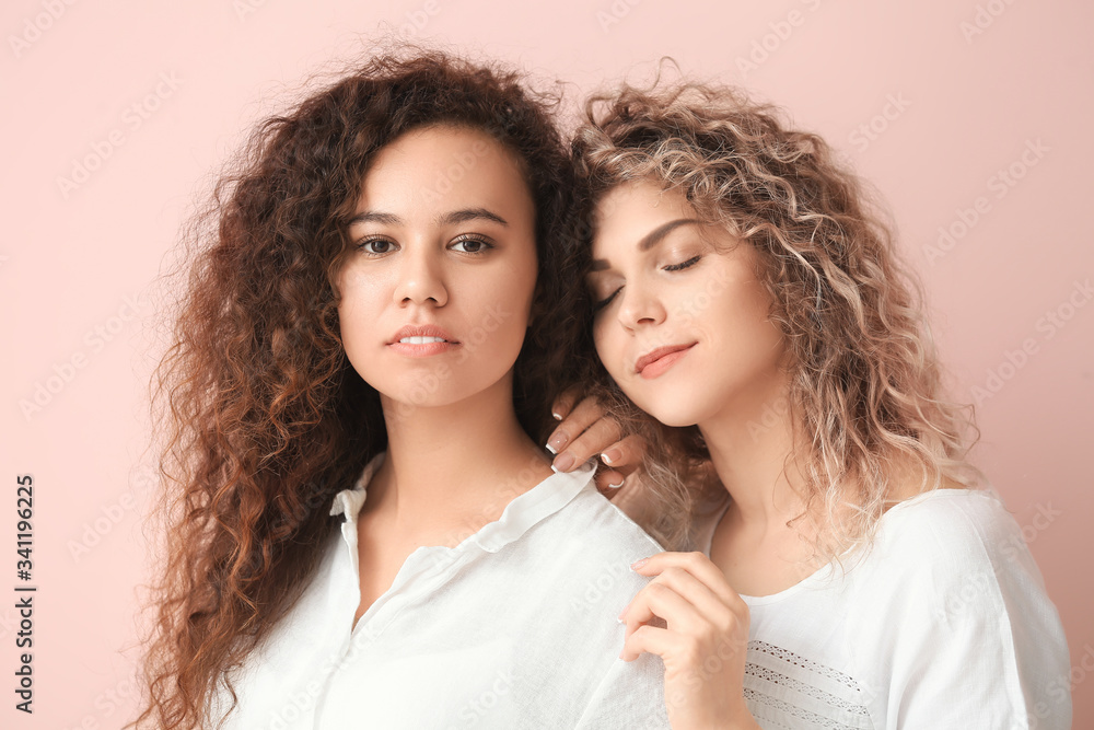 Beautiful young women on color background