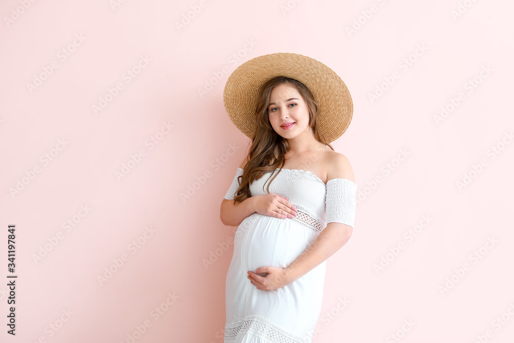 Beautiful pregnant woman on color background