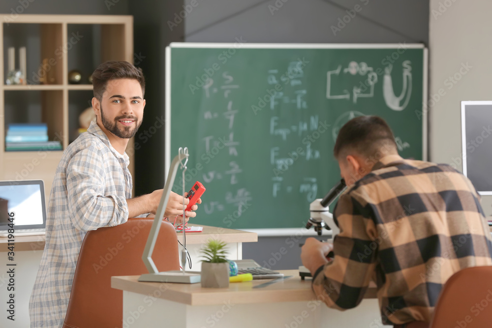 Young man at physics lesson in classroom