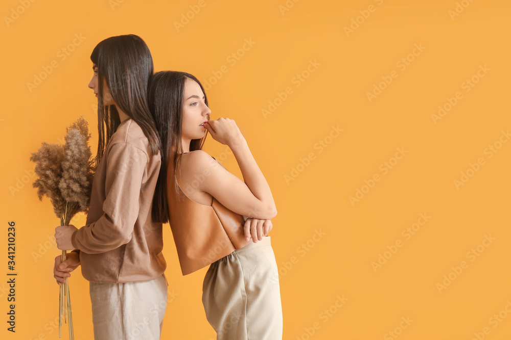 Stylish young women on color background