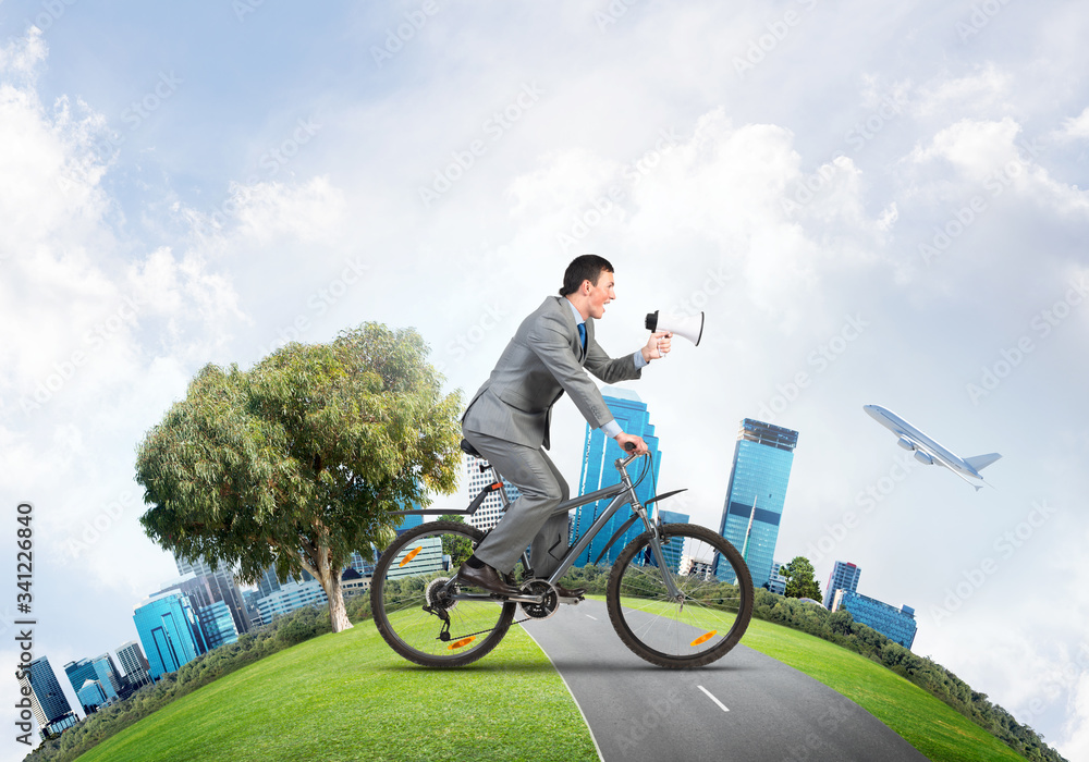 Businessman with megaphone in hand on bike