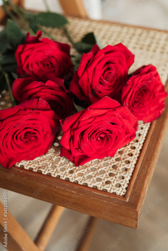 Bunch or red roses on a wooden chair