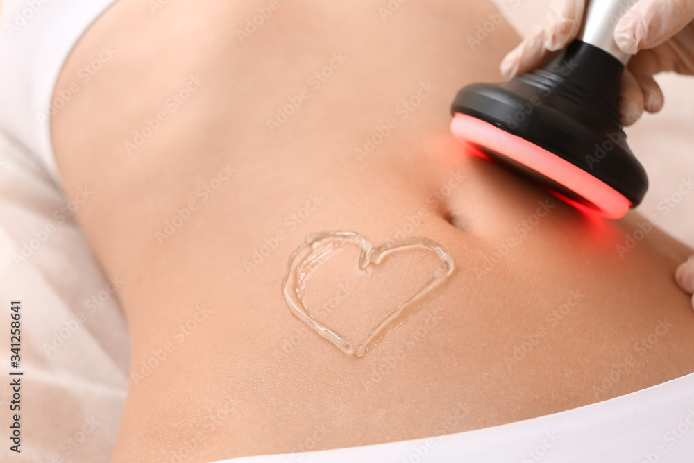 Beautiful woman undergoing procedure of anti-cellulite massage in beauty salon, closeup