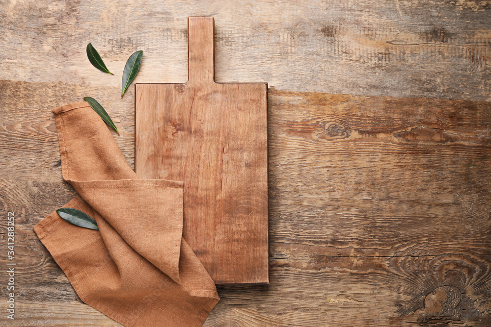 Clean napkin with cutting board on wooden background