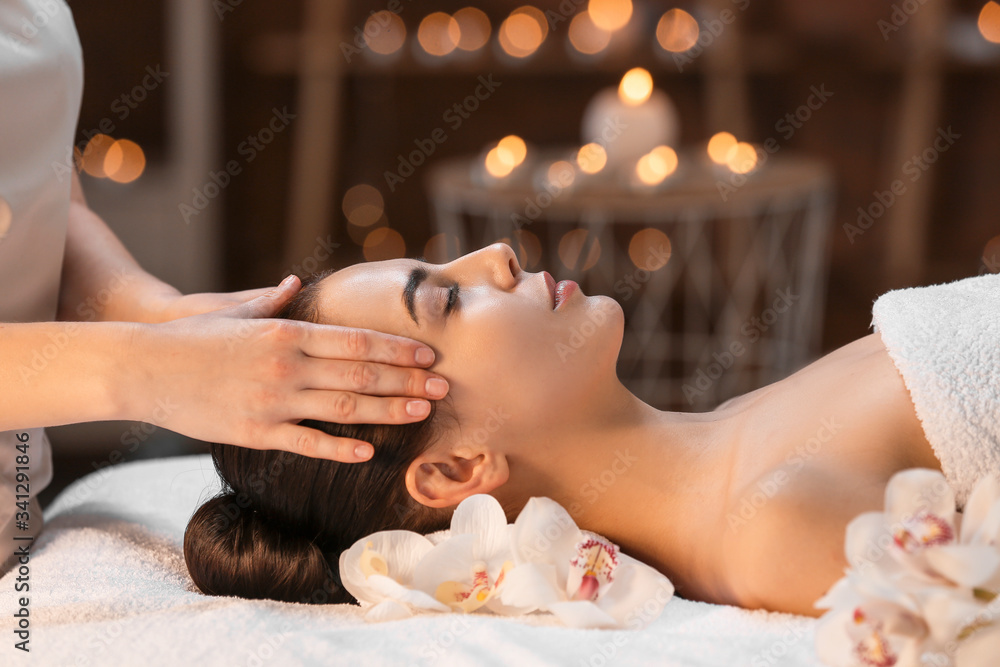 Beautiful young woman receiving massage in spa salon