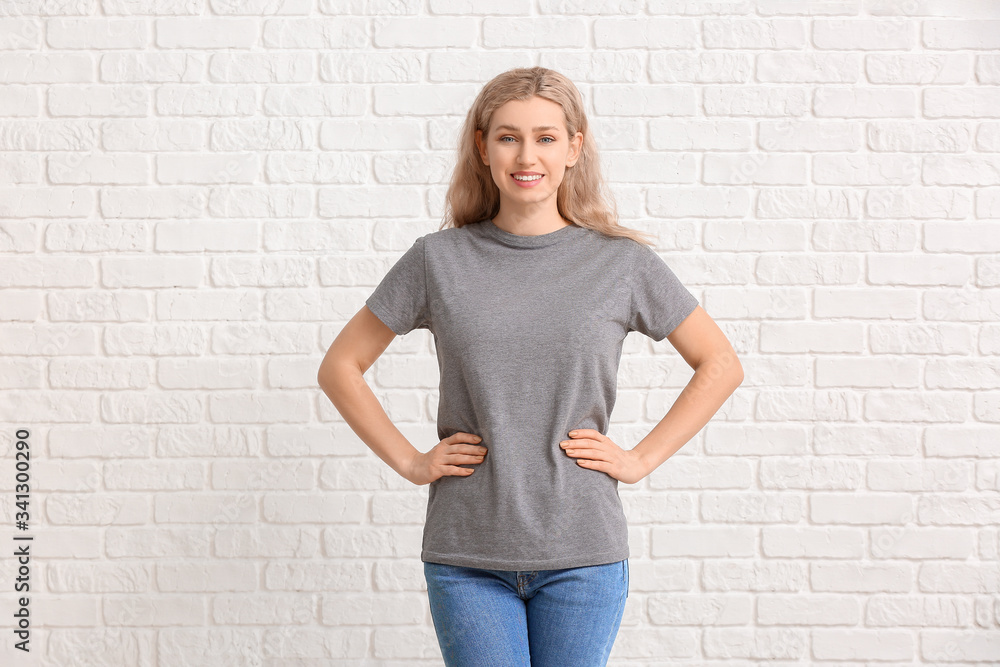 Woman in stylish t-shirt on white brick background