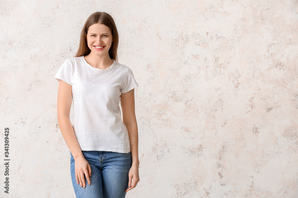 Young woman in stylish t-shirt on light background