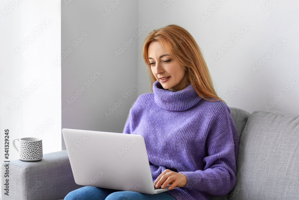 Mature woman using laptop for online learning at home