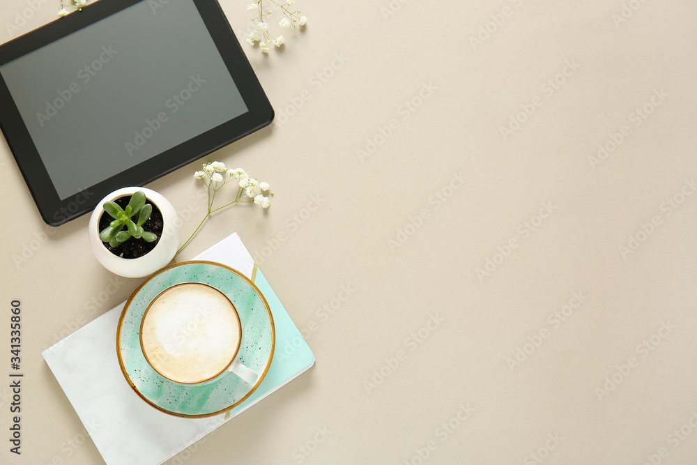 Cup of coffee, notebook, tablet PC and flowers on light background