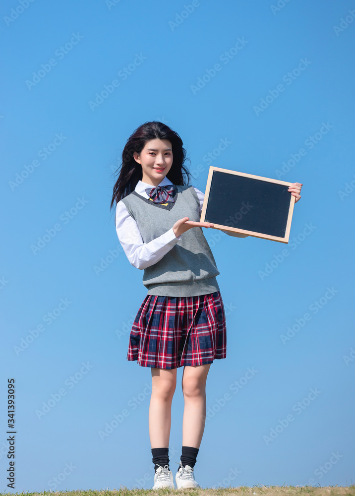 
Asian female students against blue sky background