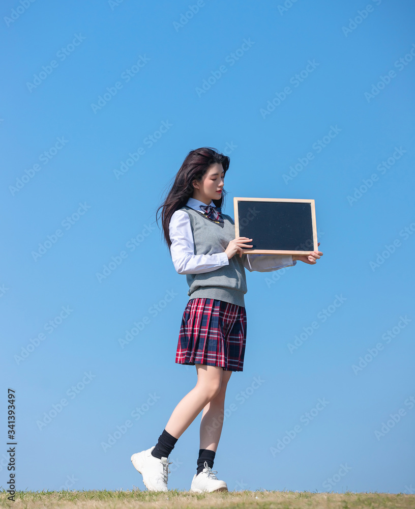 
Asian female students against blue sky background